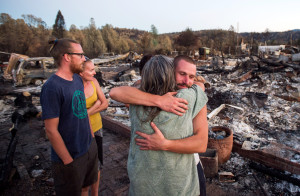 Charlie Liethen, right, embraces Sharon Dawson, who lost her home in a wildfire, in Middletown, Calif., on Monday. More than 2,000 homes had been confirmed destroyed, with the number likely to go higher as assessment continues. (AP Photo/Noah Berger)