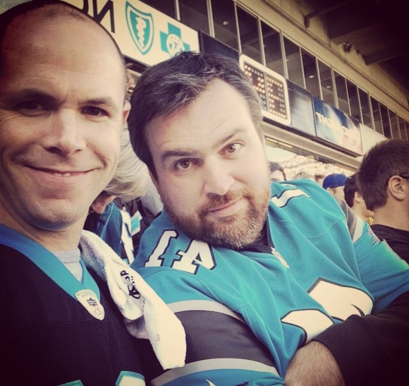 H. Garrett Droege, executive director of TechAssure Association Inc. in Charlotte, N.C., right, with a client at the Panthers vs. Arizona Cardinals game.