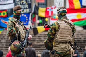 Belgian soldiers guard a memorial site at the Place de la Bourse in Brussels, Sunday, March 27, 2016. In a sign of the tensions in the Belgian capital and the way security services are stretched across the country, Belgium's interior minister appealed to residents not to march Sunday in Brussels in solidarity with the victims. (AP Photo/Geert Vanden Wijngaert)
