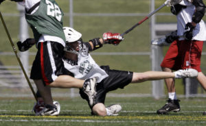 In this May 17, 2009, photo a high school lacrosse player falls onto a field of synthetic turf during practice in north Seattle. On the turf bits of ground-up tires are used as filler between the blades of artificial grass. Now the government is reconsidering whether sports fields and playgrounds made from ground-up tires can harm children's health after some Environmental Protection Agency scientists raised concerns, according to internal EPA documents. (AP Photo/Elaine Thompson, file)