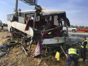 Authorities investigate the scene of a charter bus crash on northbound Highway 99 between Atwater and Livingston, Calif., Tuesday, Aug. 2, 2016. A charter bus veered off a central California freeway before dawn Tuesday and struck a pole that sliced the vehicle nearly in half, killing multiple people and sending at least five others to hospitals, authorities said. (AP Photo/Scott Smith)