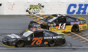 Martin Truex Jr. (78) drives past Tony Stewart (14) during a NASCAR Sprint Cup Series auto race at Chicagoland Speedway, Sunday, Sept. 18, 2016, in Joliet, Ill. (AP Photo/Nam Y. Huh)