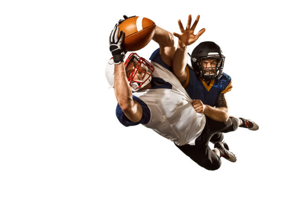 Active two american football player isolated on white background. Fit caucasian men in uniform with ball jumping over studio background in jump or motion. Human emotions and facial expressions concept. scramble concepts