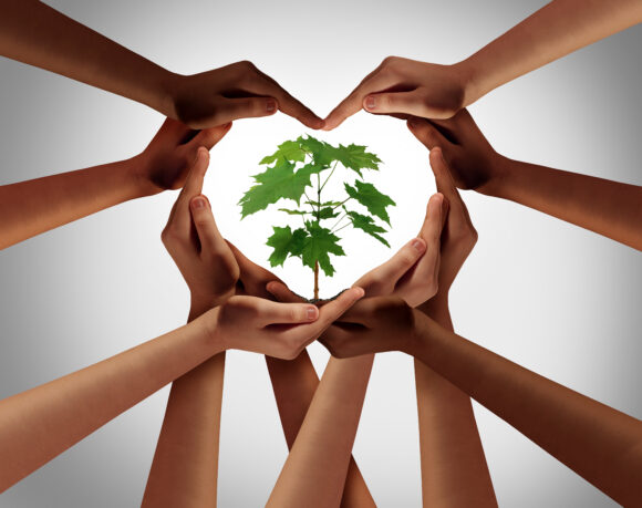 Charity concept or earth day global diversity support celebration as a community symbol for friendship and volunteer donation as a group of diverse people forming a heart shape as a composite image.