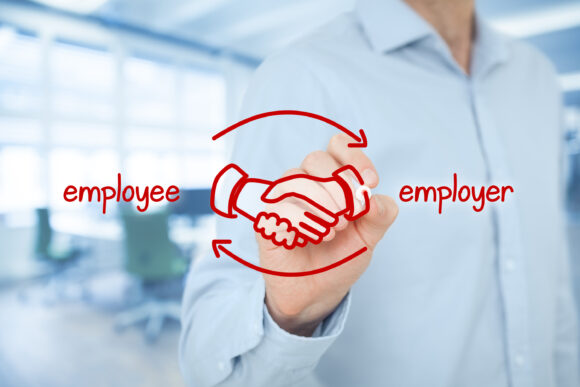 Employee and employer balanced cooperation concept. Businessman (human resources officer) draw scheme with hand shaking of employee and employer. Wide banner composition with office in background.