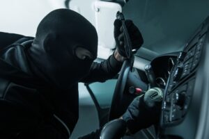 Vehicle Thief Concept Photo. Caucasian Car Thief in Black Mask.