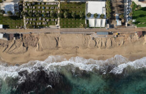 Aerial view of ocean waves breaking on a sandy beach. Beach erosion after coastal flooding. Protaras Cyprus.