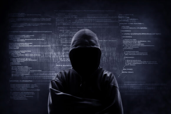 Internet crime concept. Hacker working on a code on dark digital background with digital interface around.