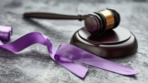 Concept of Domestic Violence Law Represented by Violet Ribbon and Gavel on Grey Background