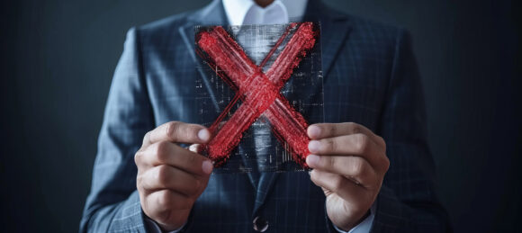 Businessman holding hologram of red x mark for failed certification or audit concept with copy space