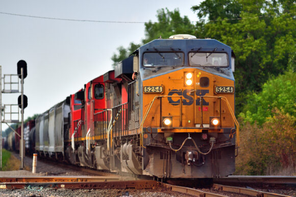 Bartlett, Illinois, USA. An off-road CSX Transportation locomotive leads a Canadian National Railway freigh train through a crossing of the tracks of the Canadian Pacific Railway also shared by Chicago's commuter railroad, Metra. The crossing of the two lines is at Spaulding Junction. As with all such railway juctions in the United States in the United States, crossings are protected by signals in all directions. One such signal example can be seen just to the left of the oncoming train.