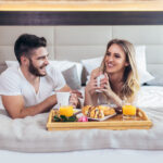 Romantic happy couple having breakfast in bed