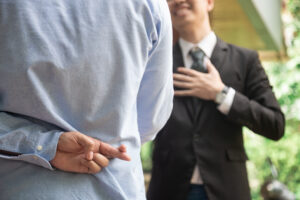 Business man shaking hand with lie sign Represents the betrayal.