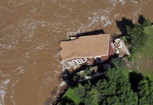 In this aerial photo, a home is pulled into the fast currents of the flooded South Platte River off of U.S 34 between Greeley and Kersey, Colo., Monday, Sept. 16, 2013. Weary Colorado evacuees have begun returning home after days of rain and flooding, but Monday's clearing skies and receding waters revealed only more heartbreak: toppled houses, upended vehicles and a stinking layer of muck covering everything. (AP Photo/The Greeley Tribune, Joshua Polson)