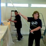 IMA Dallas employees James Dark and Sharon Sanford paint walls at a child care center.